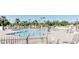 Large community swimming pool surrounded by lounge chairs, palm trees, and shade structures at 8354 E Emelita Ave, Mesa, AZ 85208