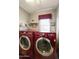 Laundry room featuring red, front-loading washer and dryer with white shelves and a window at 8354 E Emelita Ave, Mesa, AZ 85208