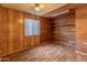 Inviting bedroom featuring wood-look floors and wood paneled walls with natural light at 8648 N 37Th Ave, Phoenix, AZ 85051
