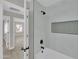 Bathroom with tub, shower, white tile, modern fixtures, and minimalist decor at 9437 E Champagne Dr, Sun Lakes, AZ 85248
