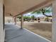 View from a covered patio overlooking desert landscaped backyard with mature tree and blue sky at 9437 E Champagne Dr, Sun Lakes, AZ 85248