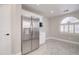 Bright kitchen features stainless steel refrigerator, white cabinetry, and an arched window at 9437 E Champagne Dr, Sun Lakes, AZ 85248
