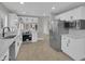 This kitchen has stainless steel appliances, white cabinets, quartz countertops, and light wood floors at 9437 E Champagne Dr, Sun Lakes, AZ 85248