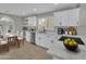 Bright kitchen with white cabinets, marble countertops, stainless steel appliances, and a dining area at 9437 E Champagne Dr, Sun Lakes, AZ 85248