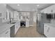 Kitchen features white cabinetry, stainless steel appliances, quartz countertops, and light wood floors at 9437 E Champagne Dr, Sun Lakes, AZ 85248