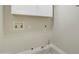 Laundry room with white cabinets and flooring, plus hookups at 9437 E Champagne Dr, Sun Lakes, AZ 85248