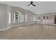Living room featuring a ceiling fan, lots of windows with plantation shutters, and light wood floors at 9437 E Champagne Dr, Sun Lakes, AZ 85248