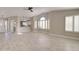 Open living room showcases modern flooring, an open kitchen, and natural light from large shuttered windows at 9437 E Champagne Dr, Sun Lakes, AZ 85248