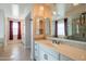 Bathroom with dual vanities, elegant mirrors, and views of the luxurious shower and walk-in closet at 9729 E Theia Dr, Mesa, AZ 85212