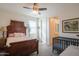 Cozy bedroom featuring an antique wooden bed frame, a ceiling fan, and access to a private bathroom at 9729 E Theia Dr, Mesa, AZ 85212