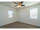 Bright bedroom with dual windows, ceiling fan and neutral carpet flooring at 9729 E Theia Dr, Mesa, AZ 85212