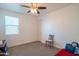 Cozy bedroom with a ceiling fan, natural light from a window, and neutral carpet flooring at 9729 E Theia Dr, Mesa, AZ 85212
