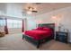 Inviting primary bedroom featuring a dark wood bed frame, a ceiling fan, and large windows with natural light at 9729 E Theia Dr, Mesa, AZ 85212