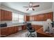 Bright office with custom built-in cabinets, desk space, and a ceiling fan for a comfortable work environment at 9729 E Theia Dr, Mesa, AZ 85212