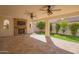 Covered patio with stone flooring, ceiling fans, fireplace and a view of the landscaped backyard at 9729 E Theia Dr, Mesa, AZ 85212