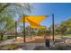 Community playground with modern equipment, shade structures, and a safe, wood-chip ground cover at 9729 E Theia Dr, Mesa, AZ 85212