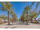 Palm-lined walkway leading to volleyball nets, offering recreational activities in a beautifully landscaped setting at 9729 E Theia Dr, Mesa, AZ 85212