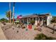 Welcoming single-story home with desert landscaping featuring palm trees and decorative plants at 10951 W Tropicana Cir, Sun City, AZ 85351