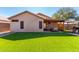 Back of home features covered patio, barbecue, artificial grass, and neutral-toned exterior paint at 11312 E Camino St, Mesa, AZ 85207