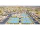 An aerial view of the community featuring tennis courts, pickleball courts, pool, and plenty of parking at 11525 E Laguna Azul Cir, Mesa, AZ 85209