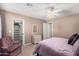 Cozy bedroom features a ceiling fan, mauve furnishings, and a walk-in closet with shelving at 11525 E Laguna Azul Cir, Mesa, AZ 85209