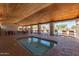 Inviting hot tub in common area with seating, lush desert landscaping and wood plank ceiling at 11525 E Laguna Azul Cir, Mesa, AZ 85209