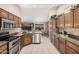 Modern kitchen featuring stainless steel appliances, tile flooring, and granite countertops at 11525 E Laguna Azul Cir, Mesa, AZ 85209