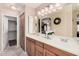 Bathroom featuring double sinks, wood cabinets, a large mirror, and access to a walk-in closet at 11525 E Laguna Azul Cir, Mesa, AZ 85209