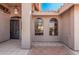 Inviting front porch with tile flooring, arched windows, and decorative entry door at 11525 E Laguna Azul Cir, Mesa, AZ 85209