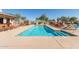 Beautiful community pool with lounge chairs and umbrellas; mountain views in the background at 11525 E Laguna Azul Cir, Mesa, AZ 85209