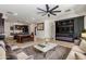 Open living area with tile floors, a modern ceiling fan, and a decorative electric fireplace at 12098 W Lone Tree Trl, Peoria, AZ 85383