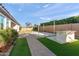 This backyard features an outdoor kitchen, artificial grass, and lush landscaping for ultimate relaxation at 12539 W Tuckey Ln, Glendale, AZ 85307