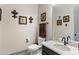 A modern half-bath with attractive fixtures, a decorative mirror, framed artwork, and a gray vanity with a white countertop at 12539 W Tuckey Ln, Glendale, AZ 85307