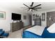 Bright bedroom features sleek furniture, a TV, and a grey color scheme with light colored carpet at 12539 W Tuckey Ln, Glendale, AZ 85307