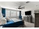 Well-lit bedroom with window shutters, a mounted TV, and a dresser, creating a comfortable and functional space at 12539 W Tuckey Ln, Glendale, AZ 85307