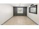 An empty dining room with hardwood floors, a modern light fixture, and a stylish accent wall with bright light at 12539 W Tuckey Ln, Glendale, AZ 85307