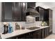 Close-up shot of the kitchen featuring dark cabinets, light countertop, stainless steel appliances, and white-tiled backsplash at 12539 W Tuckey Ln, Glendale, AZ 85307