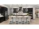 Beautiful kitchen with black cabinets, white countertops, designer lighting and seating for four at the large island at 12539 W Tuckey Ln, Glendale, AZ 85307