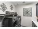A stylish laundry room equipped with modern appliances and decorative art, and storage space for household necessities at 12539 W Tuckey Ln, Glendale, AZ 85307