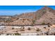 A sprawling aerial view of a desert home nestled against a mountain with scenic city views at 13023 N Joan D Arc Ave, Phoenix, AZ 85032