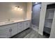 Elegant bathroom with double sinks, white cabinets, quartz counters, and a walk-in shower at 13699 S Durango Rd, Arizona City, AZ 85123