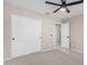 This bedroom features neutral carpeting, a ceiling fan, and a closet for storage at 1421 E Hopkins Rd, Gilbert, AZ 85295