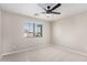 This bedroom features neutral carpeting, a ceiling fan, and natural light through a window at 1421 E Hopkins Rd, Gilbert, AZ 85295