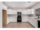 Well-lit kitchen featuring white cabinets, granite counters, and modern black appliances at 1421 E Hopkins Rd, Gilbert, AZ 85295