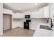 Modern kitchen with white cabinets, quartz countertops, and black appliances at 1421 E Hopkins Rd, Gilbert, AZ 85295
