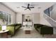 Bright living room showcasing green sofas, marble table, modern cabinet, and staircase at 1421 E Hopkins Rd, Gilbert, AZ 85295