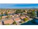 Overhead view of a waterfront neighborhood featuring red tile roofs, lush greenery, and calm lake waters at 1470 S Villas Ct, Chandler, AZ 85286