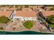 Aerial view of backyard with lush landscaping, covered patio, octagonal fire pit, and access to a tranquil lake at 1470 S Villas Ct, Chandler, AZ 85286