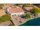 Aerial view of a backyard featuring a manicured lawn, landscaping, an octagonal fire pit, and lake access at 1470 S Villas Ct, Chandler, AZ 85286