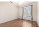 Empty bedroom featuring a large window with curtains and wood flooring at 1470 S Villas Ct, Chandler, AZ 85286